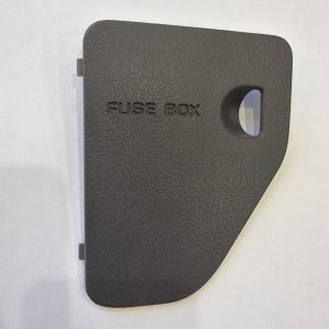 724f0242-5164-41dd-82d0-a9f97e01d691-29905-0000029bbb2dba29_file - DRT Parts | Close-up of a textured black fuse box cover with the words 'FUSE BOX' embossed on it and a small rectangular window on the right side.